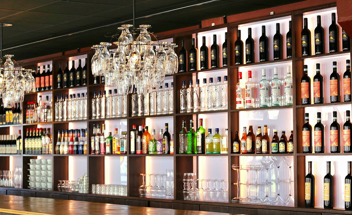 Bar med upplysta hyllor och flaskor
